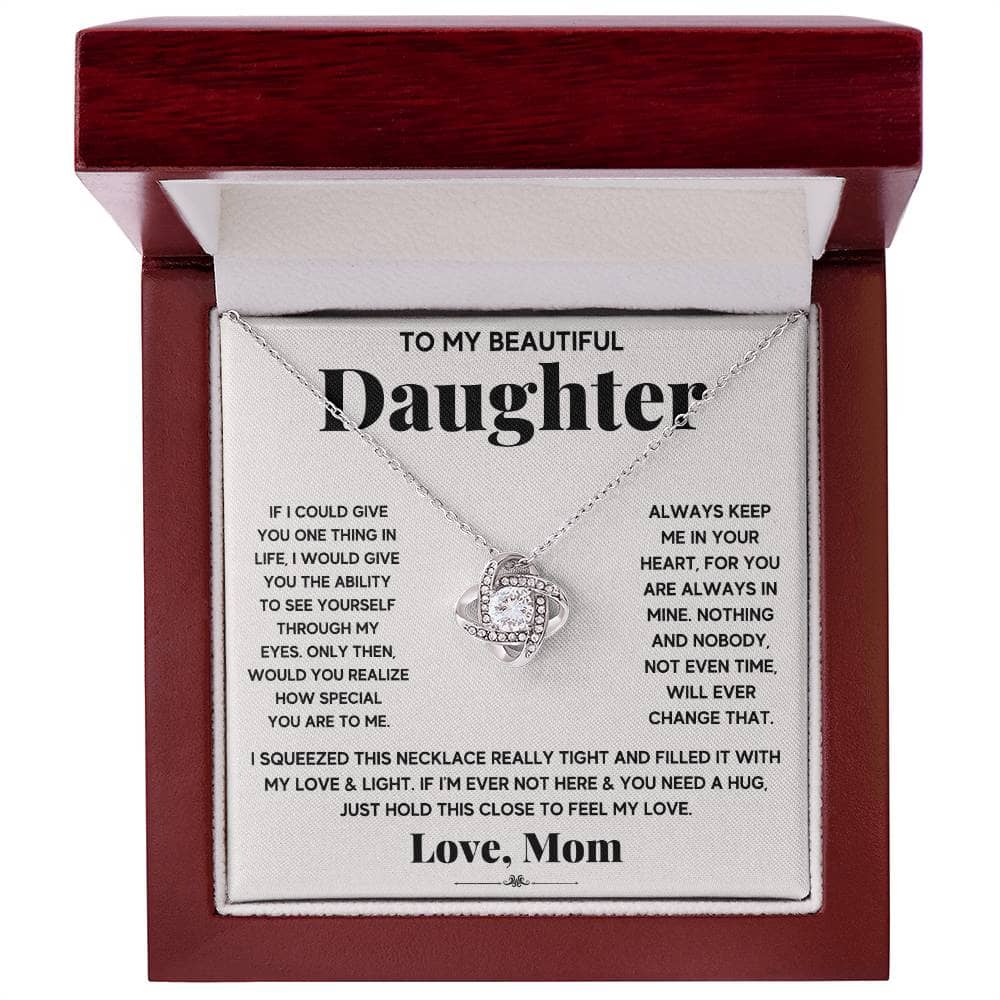 A necklace in a box, featuring a heart-shaped pendant symbolizing the timeless love between parents and daughters.