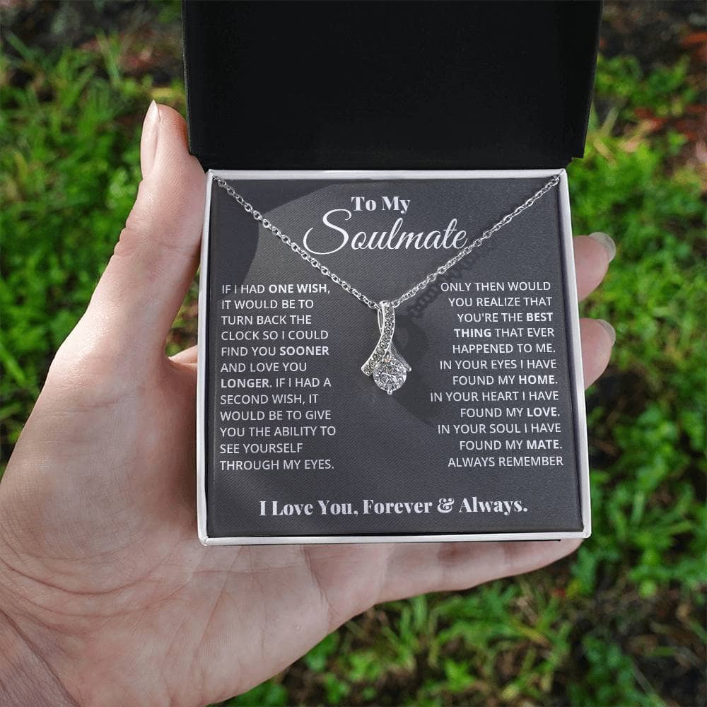 Alt text: "A hand holding a personalized Soulmate Necklace in a luxurious box, symbolizing love and commitment."