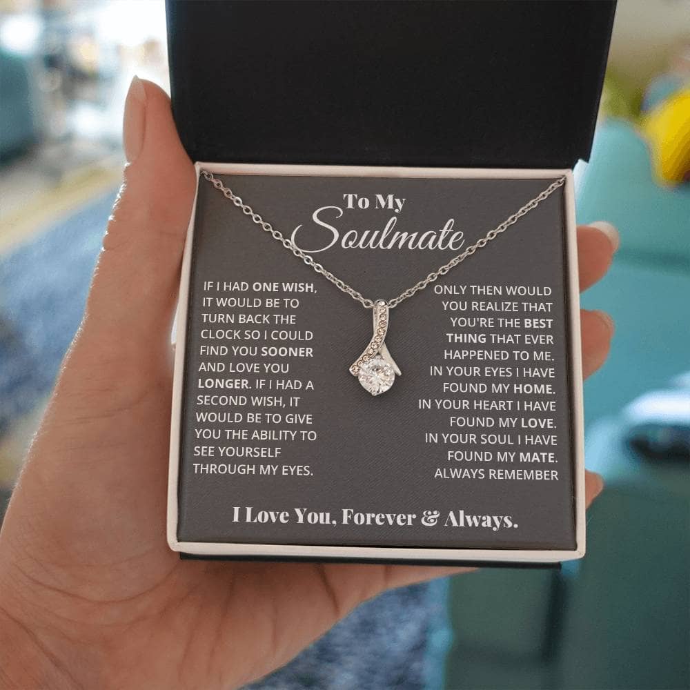 A hand holding a personalized Soulmate Necklace in a box, symbolizing love and commitment.