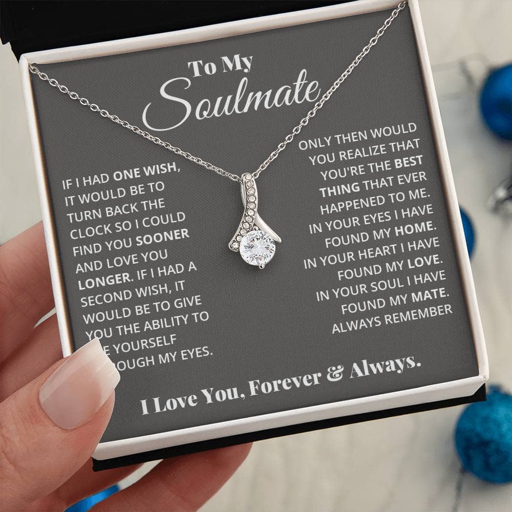 A hand holding a personalized Soulmate Necklace, symbolizing love and commitment.