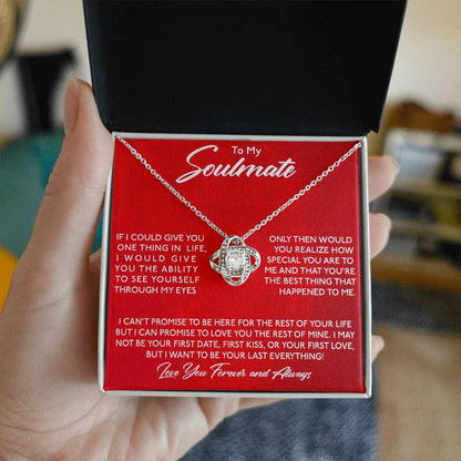 A hand holding the Special Soulmate Love Knot Necklace - Personal Touch, a symbol of unbreakable bonds and eternal love.