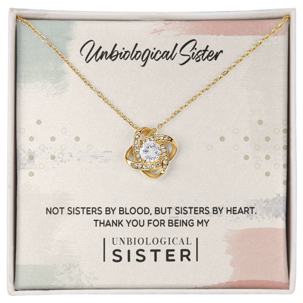 Alt text: "Unbiological Sister" Custom Love Knot Pendant in a box, featuring a gold necklace with a diamond pendant, perfect for celebrating the bond of sisterhood.