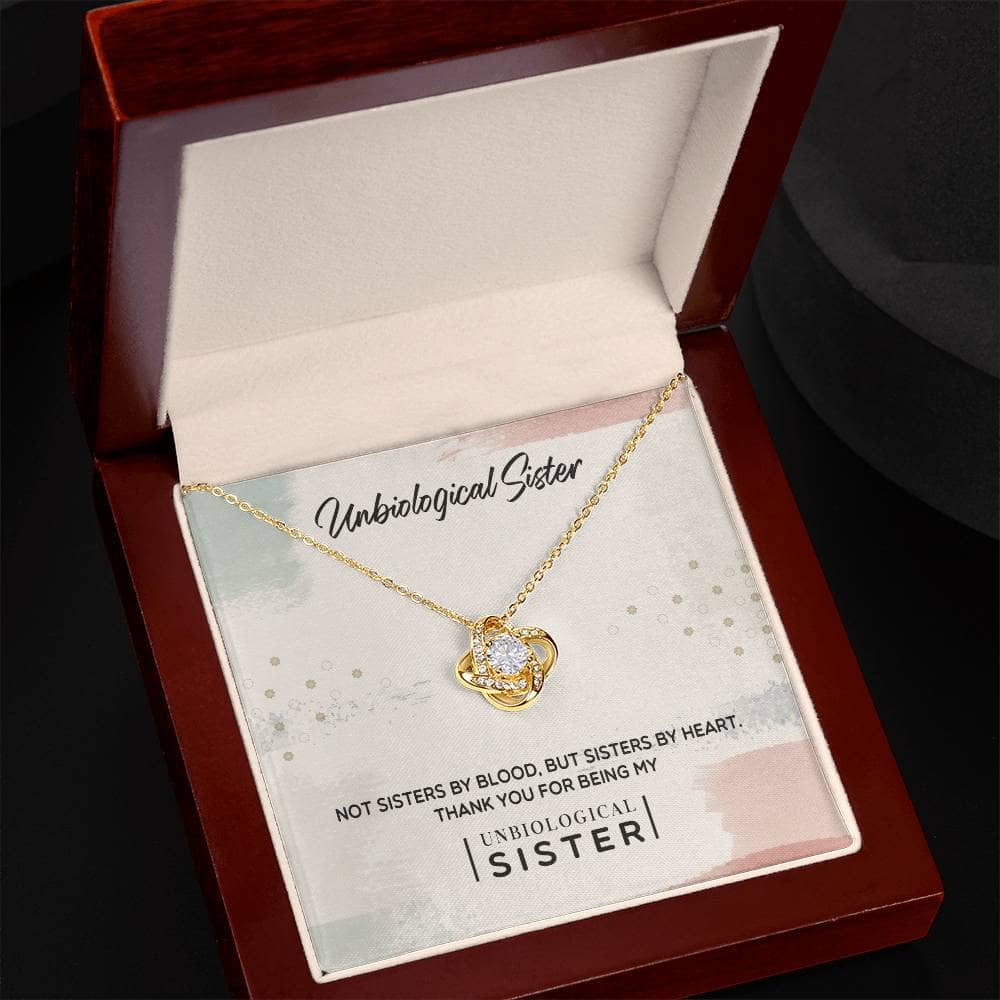 A gold necklace with a diamond pendant in a box, symbolizing the deep bond of unbiological sisters.