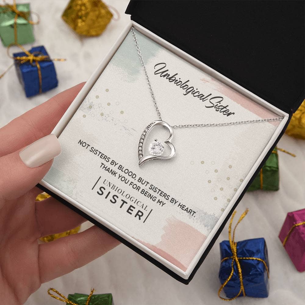 A hand holding the Unbiological Sister Tribute: Personalized Forever Love Necklace in a box, symbolizing the enduring bond of sisterhood.